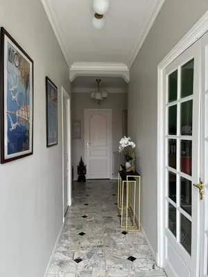 a hallway with white walls and a tile floor at Maison de charme avec jardin in Carcassonne