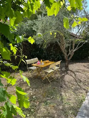 a table and chairs in a yard with a tree at Maison de charme avec jardin in Carcassonne
