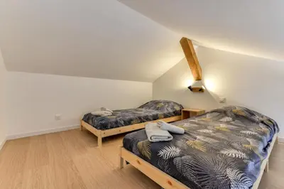 two beds in a room with white walls and wooden floors at Villa Terracotta - 8 Personnes - Proche de la mer in Peyriac-de-Mer