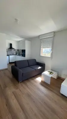 a living room with a couch and a table at Appartement T2 avec piscine in Mirepoix