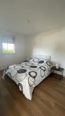 a bedroom with a bed with a black and white comforter at Appartement T2 avec piscine in Mirepoix