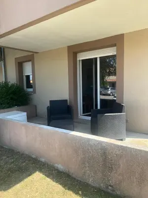 a patio with two chairs and a window at Appartement T2 avec piscine in Mirepoix