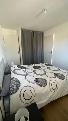 a bedroom with a large bed in a room at Appartement T2 avec piscine in Mirepoix
