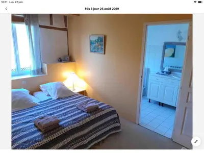 a bedroom with a bed and a bathroom with a mirror at Maison du Breilh in Mirepoix