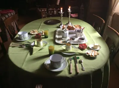a table with a green table cloth with food on it at Maison du Breilh in Mirepoix