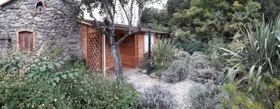 a small building in a garden with plants at La romance. in Prugnanes