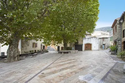 an empty street with a tree and a building at La romance. in Prugnanes