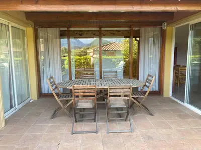 a table and chairs on a screened in porch at Charming house in Espinet domain in Quillan