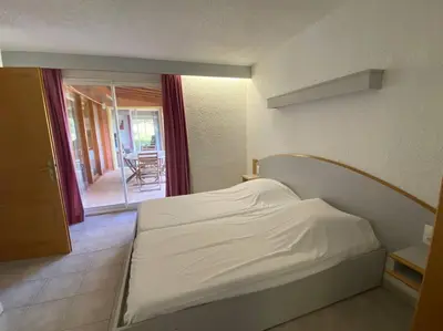 a bedroom with a white bed and a balcony at Charming house in Espinet domain in Quillan