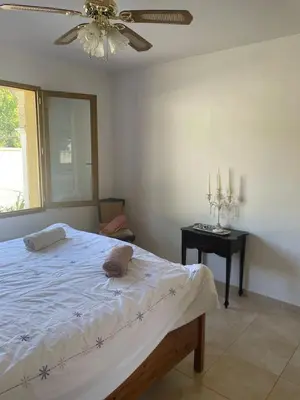 a bedroom with a bed with a ceiling fan and a table at Quillan Villa with Pool in Quillan