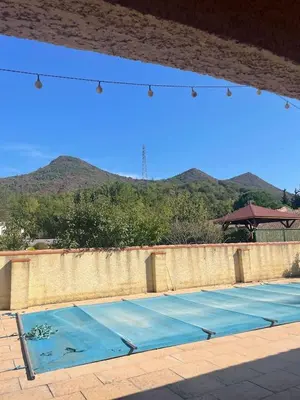a blue tennis court with mountains in the background at Quillan Villa with Pool in Quillan
