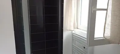 a bathroom with black tiled walls and a window at Le bon coin jardin acces autonomie parking privé in Castres