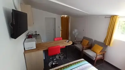 a room with a table and chairs and a television at Le bon coin jardin acces autonomie parking privé in Castres