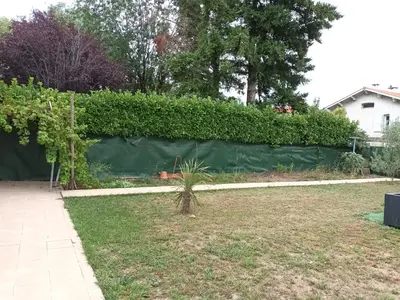 a fence in a yard with a hedge at Le bon coin jardin acces autonomie parking privé in Castres