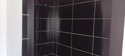 a black tiled shower with a window in a bathroom at Le bon coin jardin acces autonomie parking privé in Castres
