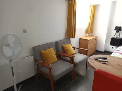 a living room with two chairs and a table at Le bon coin jardin acces autonomie parking privé in Castres