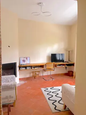 a living room with a desk and a tv at Maison de village in Saint-Hilaire