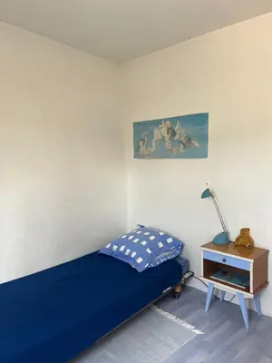 a bedroom with a bed and a table with a lamp at Maison de village in Saint-Hilaire