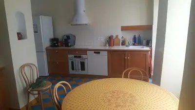 a kitchen with a table and a table and chairs at Maison de village in Saint-Hilaire