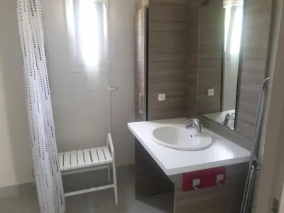 a bathroom with a sink and a shower and a mirror at CAMPING MUNICIPAL LA SAPINETTE in Quillan
