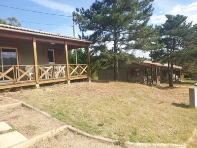 a house with a porch and a yard at CAMPING MUNICIPAL LA SAPINETTE in Quillan