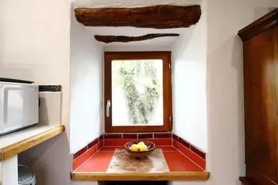 a bowl of fruit on a table in a room with a window at LA MAISONNETTE DU POTIER in Caunes-Minervois