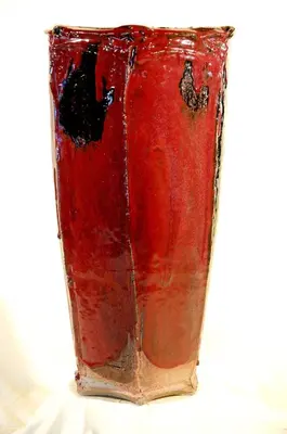 a red glass vase sitting on top of a table at LA MAISONNETTE DU POTIER in Caunes-Minervois