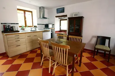 a kitchen with a wooden table and chairs in it at LA MAISONNETTE DU POTIER in Caunes-Minervois