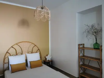 a bedroom with a bed with two pillows and a chandelier at L'althea in Carcassonne