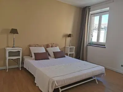 a bedroom with a large bed with two pillows at L'althea in Carcassonne