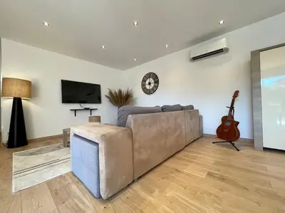 a living room with a couch and a guitar at Villa La Paz ※ Climatisée in Lézignan-Corbières