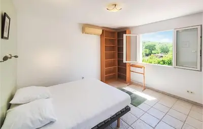 a bedroom with a white bed and a window at Beautiful Home In Prades-Sur-Vernazobre in Prades-sur-Vernazobre