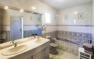 a bathroom with two sinks and a tub and a toilet at Beautiful Home In Prades-Sur-Vernazobre in Prades-sur-Vernazobre