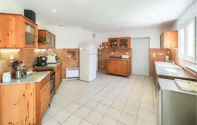 a large kitchen with wooden cabinets and appliances at Beautiful Home In Prades-Sur-Vernazobre in Prades-sur-Vernazobre