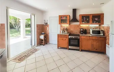 a kitchen with wooden cabinets and a stove at Beautiful Home In Prades-Sur-Vernazobre in Prades-sur-Vernazobre
