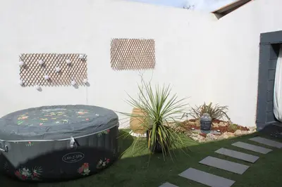 a black ottoman sitting next to a white wall at Gîte La Tchoupetta in Peyriac-de-Mer