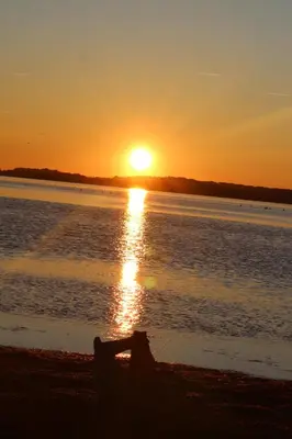 a sunset on the beach with the sun setting over the water at Gîte La Tchoupetta in Peyriac-de-Mer