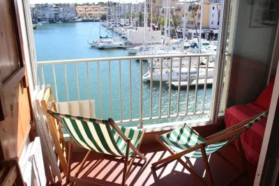 two chairs on a balcony with a view of a marina at Studio Gruissan Vue Port in Gruissan