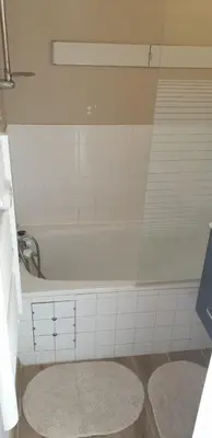 a bathroom with a white tub and a rug at Studio Gruissan Vue Port in Gruissan