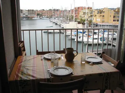 a table with a view of a marina with boats at Studio Gruissan Vue Port in Gruissan