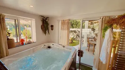 a jacuzzi tub in the corner of a room at Tropical Lodge SPA Narbonne in Narbonne