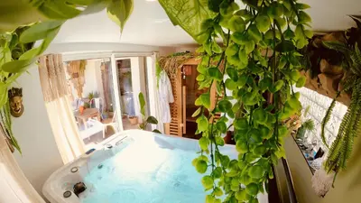 a bath tub in a room with a plant at Tropical Lodge SPA Narbonne in Narbonne