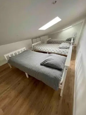 two beds in a room with wooden floors at Magnifique appartement Narbonne in Narbonne