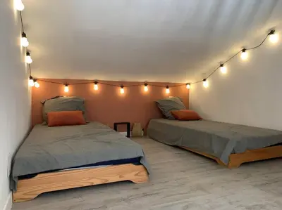 two beds in a room with lights on the wall at Casa del Sola in Mosset