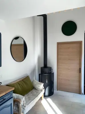 a living room with a couch and a wood stove at Casa del Sola in Mosset