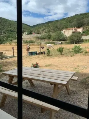 a wooden bench sitting in front of a window at Casa del Sola in Mosset