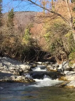 a river with snow on the rocks and trees at Casa del Sola in Mosset