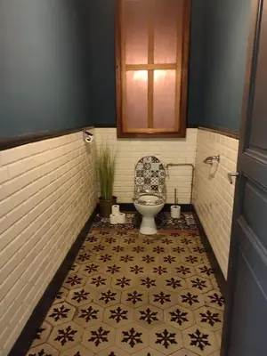 a bathroom with a toilet and a tile floor at La Scierie in Quillan