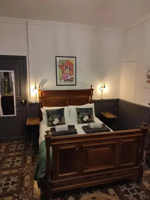 a bedroom with a wooden bed with two pillows at La Scierie in Quillan