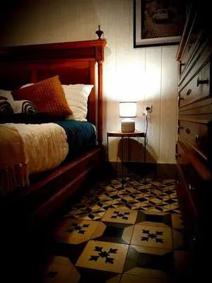 a bedroom with a bed and a table with a lamp at La Scierie in Quillan
